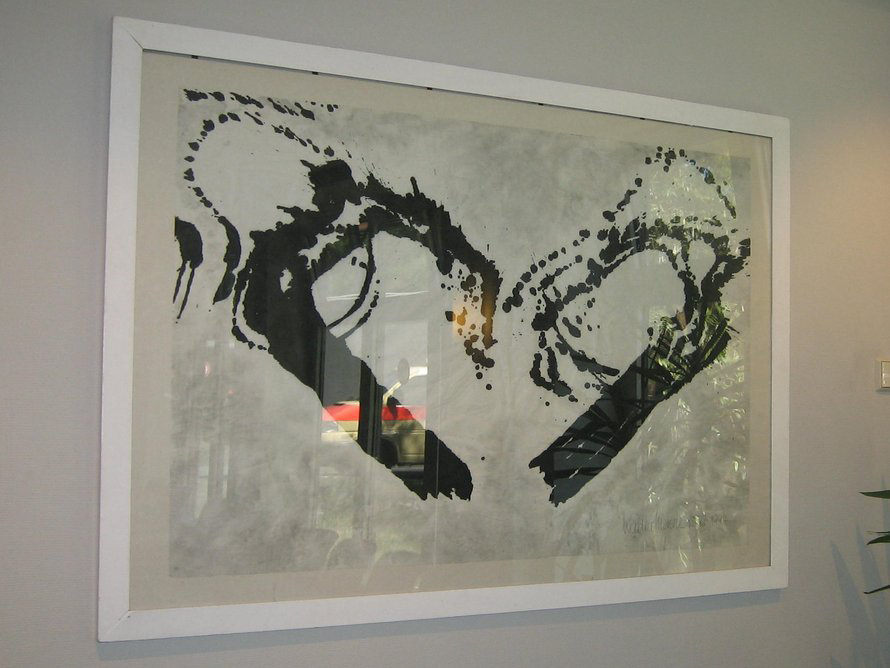 Großformatiges, weiß gerahmtes Kunstwerk mit zwei abstrakten, schwungvollen schwarzen Tuschformen auf hellem Grund. Im Glas spiegeln sich Fensterreflexionen.